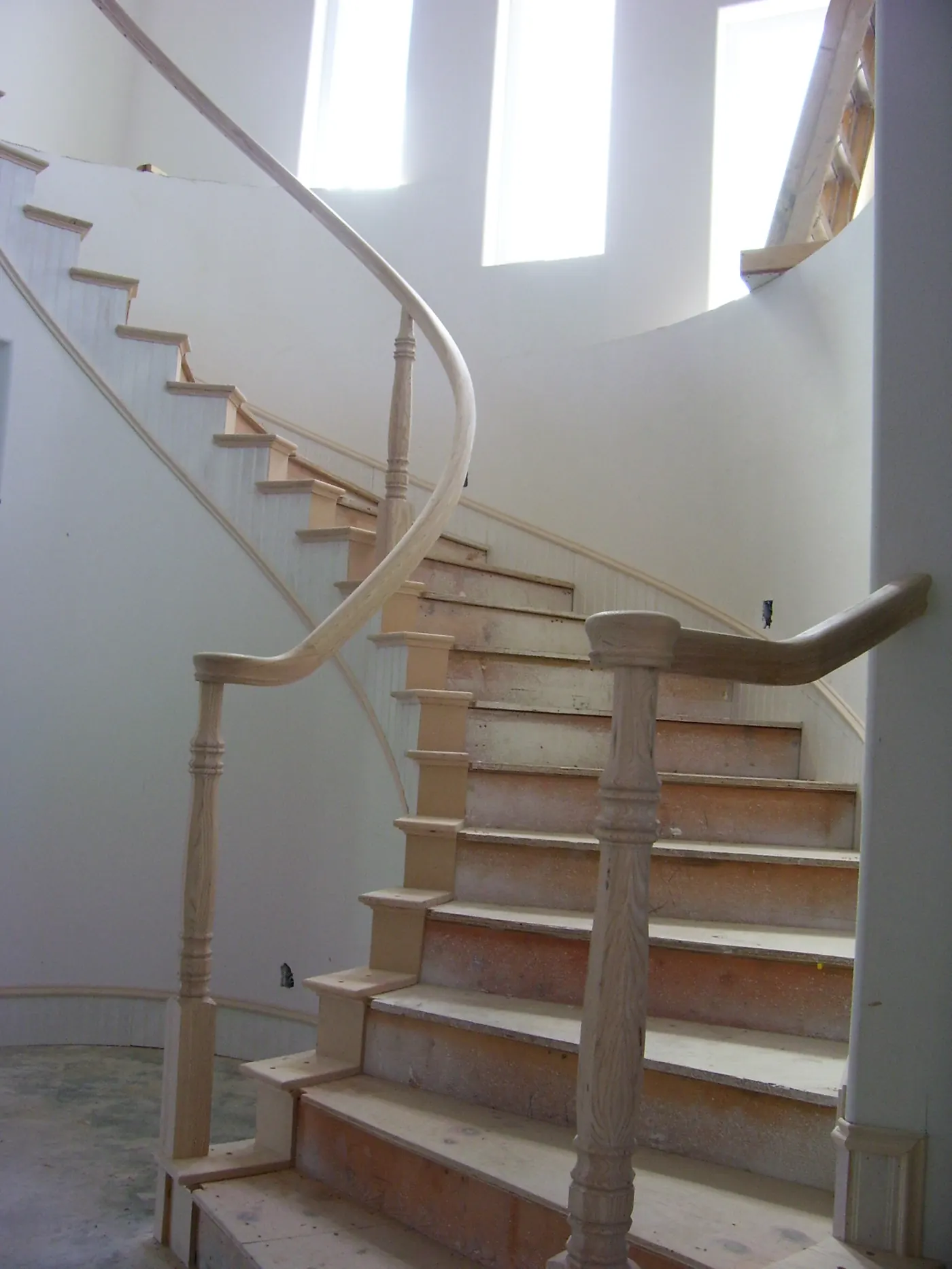 Curved staircase framing inside the Huntington Beach custom home